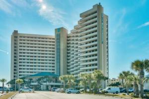 a large building with cars parked in a parking lot at The Scallop by Brightwild-Beachfront Condo in Destin