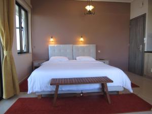 a bedroom with a large white bed and a wooden bench at Kallisto studios in Gythio