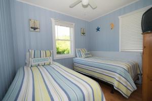 2 camas en una habitación con paredes azules en The Montauk Soundview en Montauk