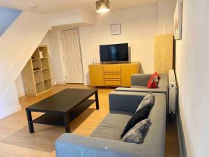 uma sala de estar com um sofá e uma mesa de centro em 4 bed House Royal Leamington Spa with free parking em Leamington Spa