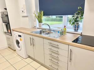 a kitchen with a sink and a dishwasher at 4 bed House Royal Leamington Spa with free parking in Leamington Spa