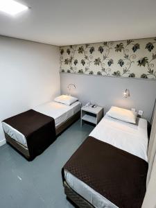 two beds in a room with two beds sidx sidx sidx at Life Hotel in Canoas