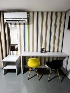 Habitación con escritorio y silla amarilla. en Life Hotel, en Canoas