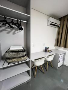 a room with a desk and a bed and chairs at Life Hotel in Canoas