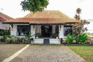 uma casa com telhado de azulejo e uma entrada em Griya Merbabu Asri Homestay (up to 14pax @ Salatiga central) em Salatiga