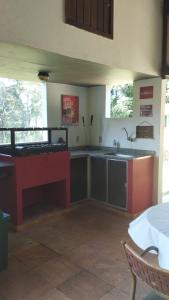 una cocina con encimeras y una mesa en una habitación en Sítio Vila de Santa Barbara, en Caeté