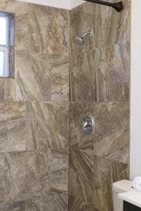 um chuveiro na casa de banho com uma parede de pedra em Very cute and comfy Apartment em Las Vegas