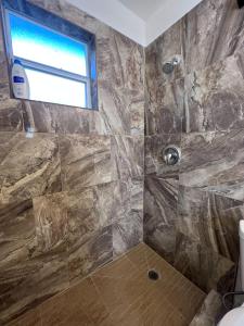 a bathroom with a shower with a stone wall at Very cute and comfy Apartment in Las Vegas