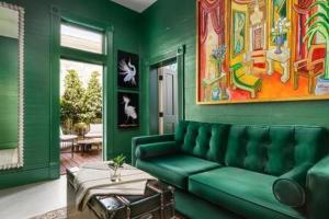 キーウェストにあるGreen Room at the Grand Maloneyの緑豊かなリビングルーム(ソファ、テーブル付)