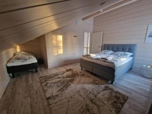 a attic bedroom with two beds and a rug at Lymyilevi in Levi