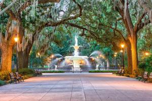 una fuente en medio de un parque con árboles en Planters Inn on Reynolds Square en Savannah