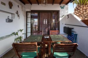 uma sala de jantar com uma mesa de madeira e cadeiras em Bungalow Montecastillo i1 em Caleta de Fuste