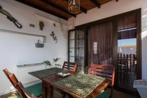 a dining room with a wooden table and chairs at Bungalow Montecastillo i1 in Caleta De Fuste