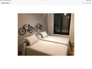 1 dormitorio con 2 camas y una bicicleta en la pared en PISO EN SANTIAGO en Santiago de Compostela