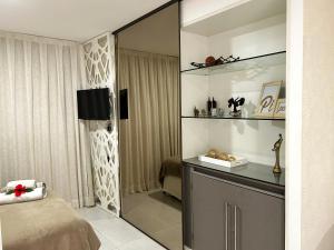 1 dormitorio con cama y espejo en Flat todo ambientado no coração de Pipa - Solar Água Apart Hotel, en Pipa