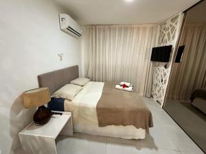 a bedroom with a large bed and a night stand at Flat todo ambientado no coração de Pipa - Solar Água Apart Hotel in Pipa +10 photos