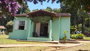 una pequeña casa verde con porche en Sítio Vila de Santa Barbara, en Caeté