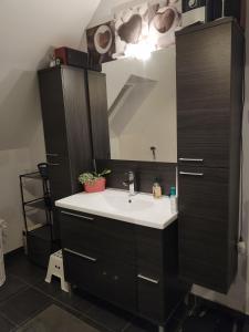 La salle de bains est pourvue d'un lavabo et d'un miroir. dans l'établissement OMAHA-BEACH maison cosy, à Saint-Laurent-sur-Mer