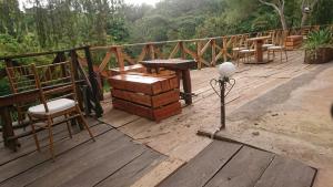 una terrazza in legno con tavolo e panca di LUSHOTO EXECUTIVE LODGE a Lushoto