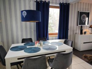 stół jadalny z krzesłami i niebieską lampą w obiekcie Villove Domy Spa w mieście Rajcza