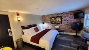 Habitación de hotel con cama y pared de ladrillo en Gunstock Inn & Suites en Gilford