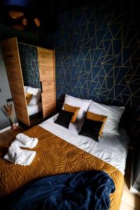 a bedroom with a large bed with a blue wall at Apartament Olimpijska przy jeziorze Ukiel in Olsztyn
