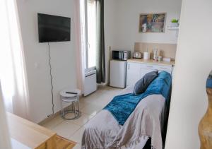 Zimmer mit einer Küche mit einem Bett und einem TV in der Unterkunft Cosy Casa entre Paris et Disney in Neuilly-Plaisance