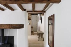 a living room with white walls and a fireplace at Two Rose Walk Cottage Cotswolds in Moreton in Marsh