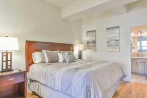 a white bedroom with a large bed and a window at The Executive Loft - Walk to Sanford Stadium in Athens