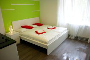 a bedroom with a bed with two red slippers on it at Budget Apartment in Prague