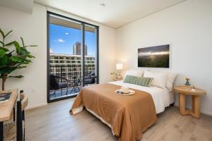 a bedroom with a bed and a large window at Sun Berry Waikiki Residence in Honolulu