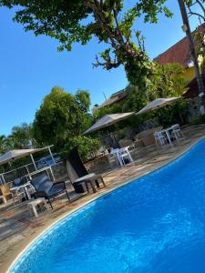 uma piscina com cadeiras e guarda-sóis ao lado de um resort em D' Franchesis Hostal em Juan Dolio