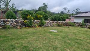 una pared de piedra en un patio con flores en Vistaverdeboquete en Boquete