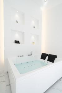 una vasca da bagno in una camera bianca con due sedie di Aqua Viva - Playa San Juan a Playa de San Juan