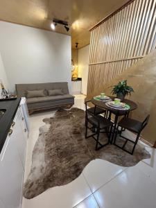 uma sala de estar com uma mesa e cadeiras e um sofá em Lofts Urbano em Urubici