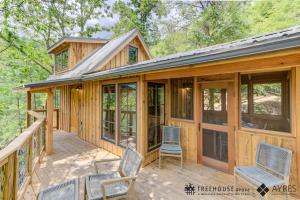 a cabin with glass doors and chairs on a deck at The Cottonwood in Treehouse Grove at Norton Creek in Gatlinburg