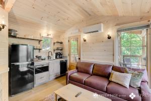 a living room with a couch and a kitchen at The Cottonwood in Treehouse Grove at Norton Creek in Gatlinburg