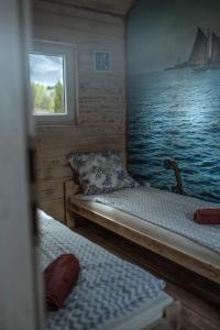 Cette chambre comprend 2 lits et une fenêtre sur un bateau. dans l'établissement Bajkowe Domki Marzeń Krecik, à Węgorzewo