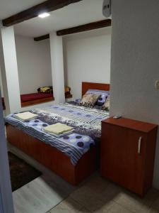 sypialnia z łóżkiem i drewnianą szafką w obiekcie S.R.C BELLA CASA w mieście Crvena Voda