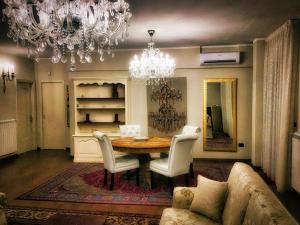comedor con mesa, sillas y lámpara de araña en Erania Apartments en Sala Consilina