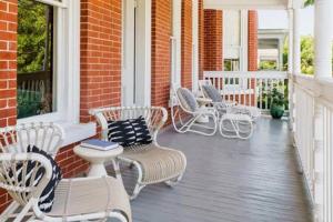 a porch with white chairs and tables at Yellow Room at Grand Maloney in Key West