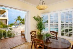 uma sala de jantar com uma mesa e uma varanda em Grand Marina Suite by Brightwild-Waterfront Condo em Key West