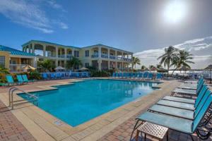 a large swimming pool with blue chairs and condos at Grand Marina Suite by Brightwild-Waterfront Condo in Key West