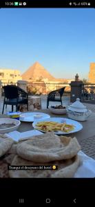 a table with plates of food on top at Live pyramids in Cairo