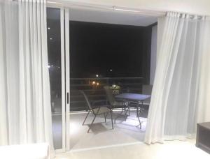 een kamer met een balkon met een tafel en stoelen bij Kapowlito Real Estate Casa Cocobiacoweg in Paramaribo