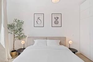 a bedroom with a white bed and two pictures on the wall at Stylish Retreat in Bivange Roeser in Roeser
