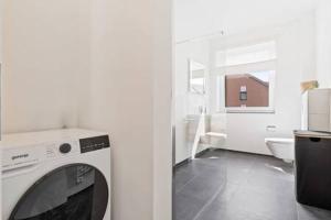 Habitación con baño blanco con lavadora. en Stylish Retreat in Bivange Roeser en Roeser