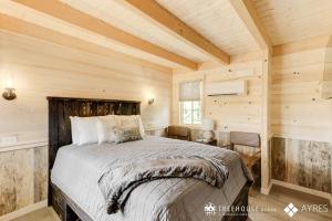 ガトリンバーグにあるThe Hickory in Treehouse Grove at Norton Creekの木製の壁の部屋にあるベッドのある寝室