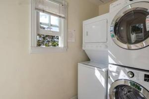a laundry room with a washing machine and a window at Coral Cove #1 by Brightwild in Key West