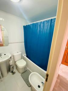 een badkamer met een wastafel en een blauw douchegordijn bij Apartamento La cala 2 in Cala del Moral